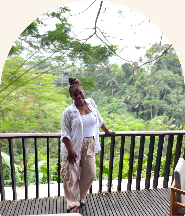 Brandi on the balcony of The Maya Resort in Bali, jungle canopy behind her