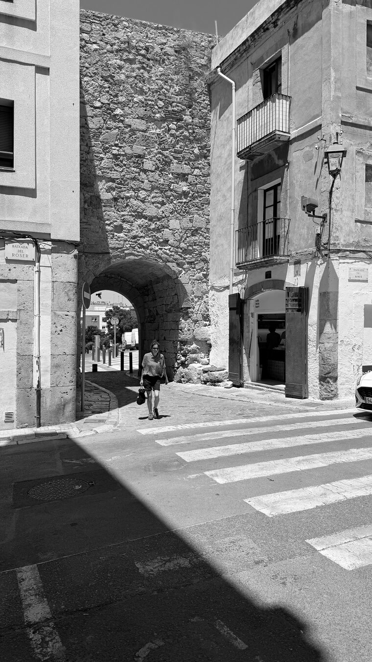 Black and white photograph of a stone archway and crossing